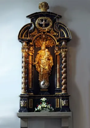 Goldene Marienstatue mit Kind auf einem dunklen Barockaltar.