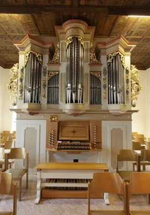 Barocke Kirchenorgel mit Goldschmuck und hölzernem Spieltisch.